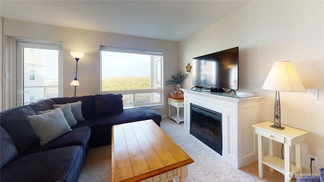 carpeted living room with a glass covered fireplace