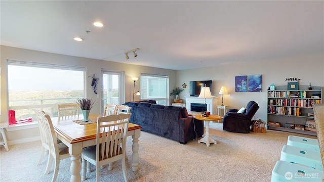 dining space featuring track lighting, recessed lighting, a fireplace, and carpet floors