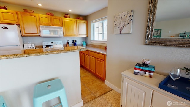 kitchen with recessed lighting, baseboards, and white appliances