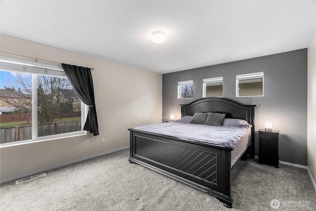 carpeted bedroom featuring baseboards and visible vents