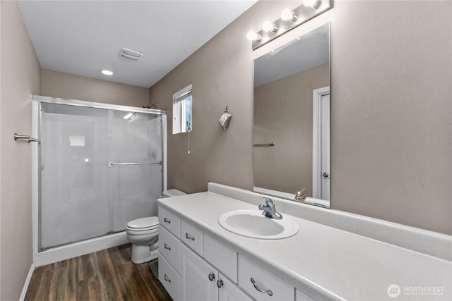 full bathroom with vanity, wood finished floors, toilet, and a shower stall