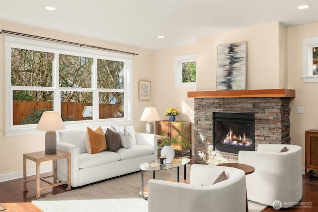 living area with wood finished floors, recessed lighting, a fireplace, and baseboards