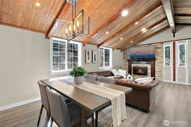 dining room with wooden ceiling, a stone fireplace, lofted ceiling with beams, and wood finished floors