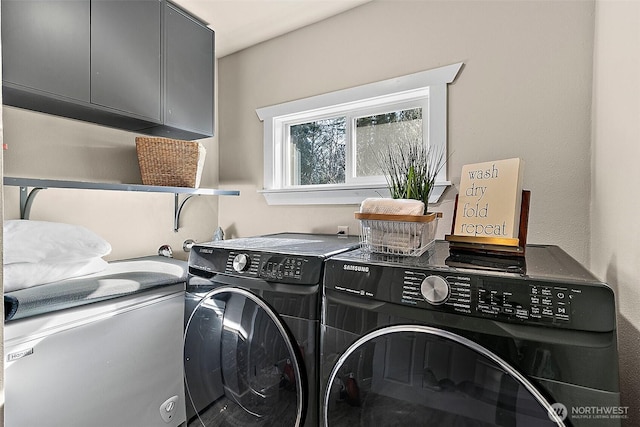 washroom with cabinet space and washer and dryer