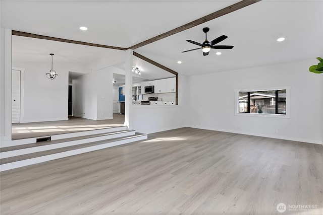 unfurnished living room with light wood-style floors, recessed lighting, lofted ceiling with beams, and ceiling fan with notable chandelier