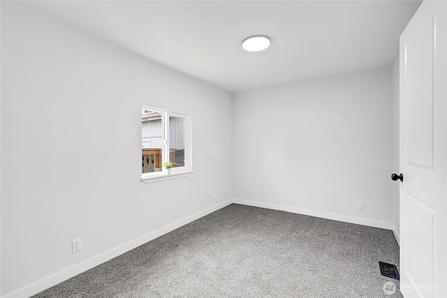 spare room featuring carpet floors, visible vents, and baseboards