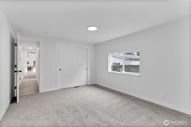 unfurnished bedroom featuring a closet, carpet, and baseboards