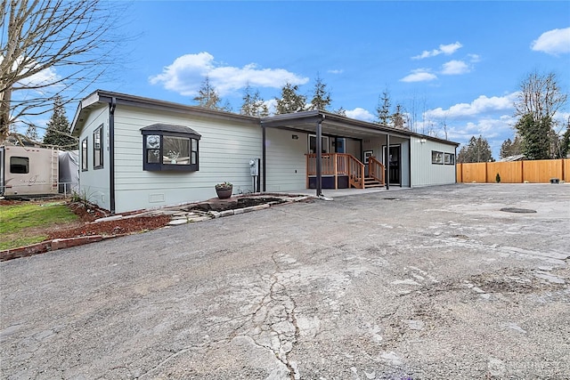 view of front of property with a carport, crawl space, fence, and driveway