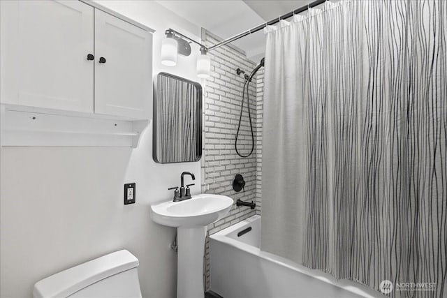 bathroom with toilet, shower / bathtub combination with curtain, and a sink