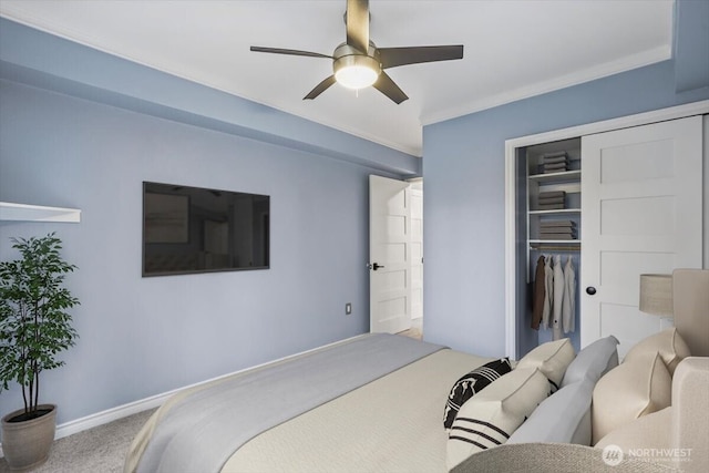 carpeted bedroom with ornamental molding, baseboards, a closet, and ceiling fan