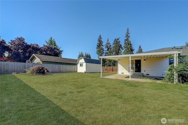 view of yard with a storage unit, a patio, an outbuilding, and a fenced backyard