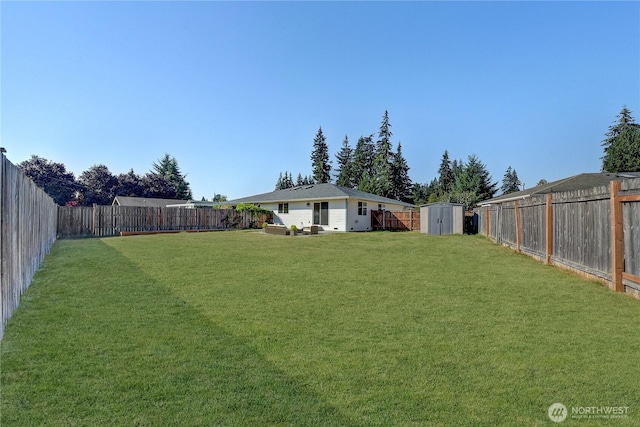 view of yard featuring a fenced backyard, a storage unit, and an outdoor structure