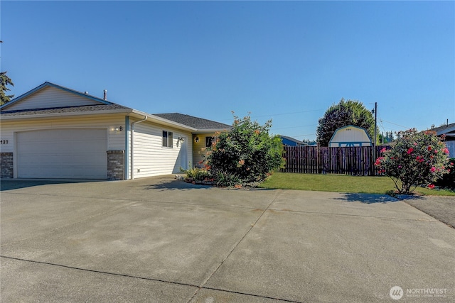 view of side of home featuring fence, concrete driveway, a garage, a lawn, and brick siding