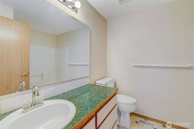 bathroom featuring vanity, visible vents, baseboards, walk in shower, and toilet