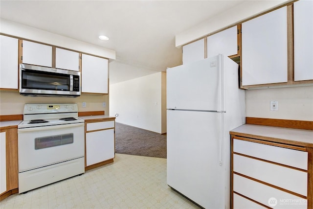 kitchen with recessed lighting, light floors, white appliances, and light countertops