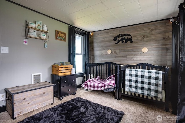 bedroom featuring carpet floors, wood walls, and visible vents