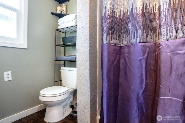 bathroom featuring baseboards, toilet, and wood finished floors