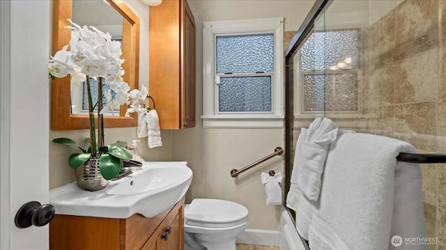 full bath with a shower with door, toilet, vanity, and baseboards