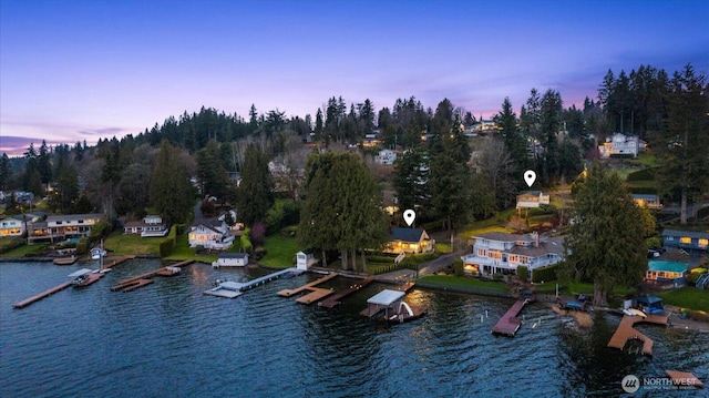 aerial view at dusk featuring a water view