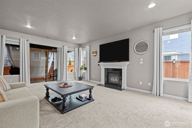 living area featuring visible vents, baseboards, a fireplace with flush hearth, recessed lighting, and carpet flooring