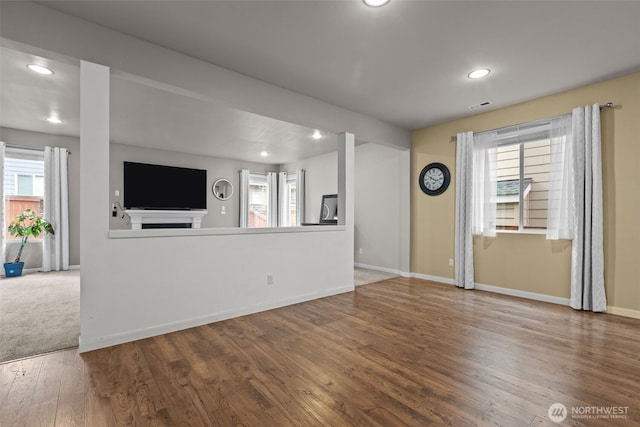 unfurnished living room with recessed lighting, visible vents, baseboards, and wood finished floors