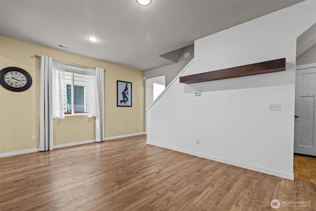 unfurnished room featuring wood finished floors, visible vents, and baseboards