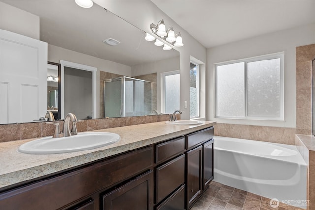 full bathroom featuring visible vents, a shower stall, a garden tub, and a sink