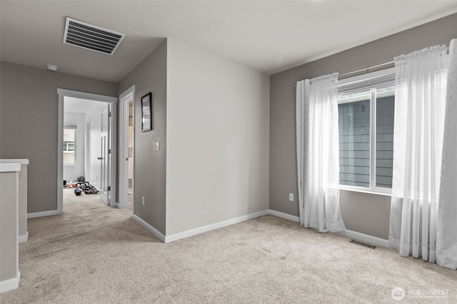 spare room featuring visible vents, baseboards, and carpet floors