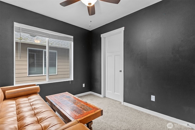 carpeted living room featuring a ceiling fan and baseboards