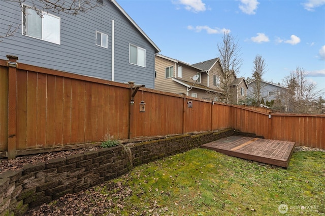 view of yard with a residential view, a deck, and a fenced backyard