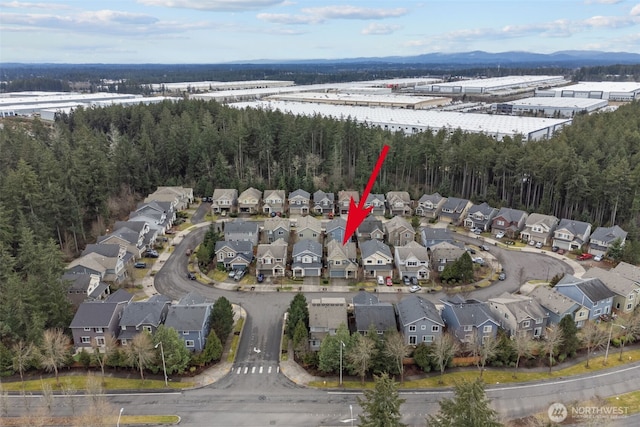 drone / aerial view featuring a residential view and a view of trees