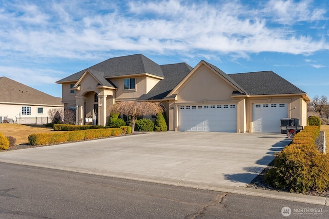 view of front of home with a garage, driveway, and stucco siding