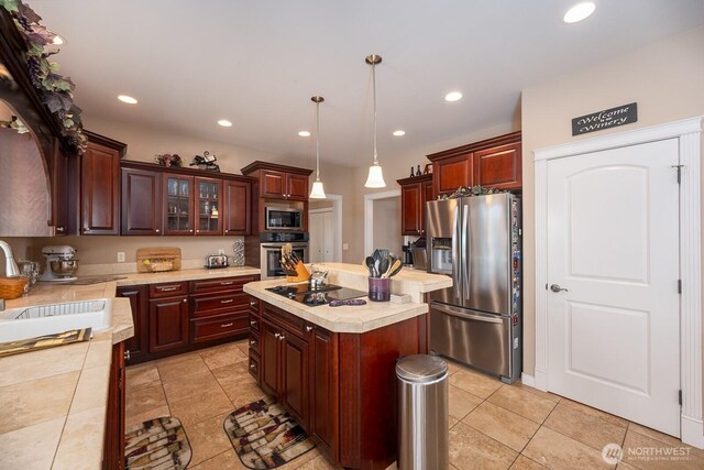 kitchen featuring a kitchen island, recessed lighting, a sink, appliances with stainless steel finishes, and pendant lighting