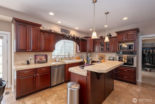 kitchen with a sink, appliances with stainless steel finishes, recessed lighting, and light countertops