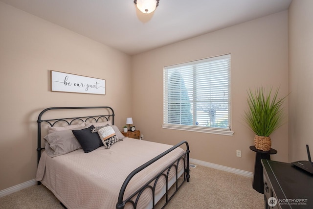 bedroom with baseboards and light carpet