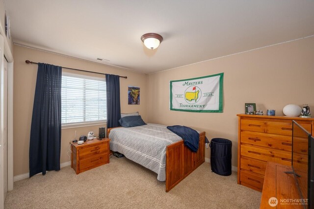 bedroom with baseboards, visible vents, and light carpet