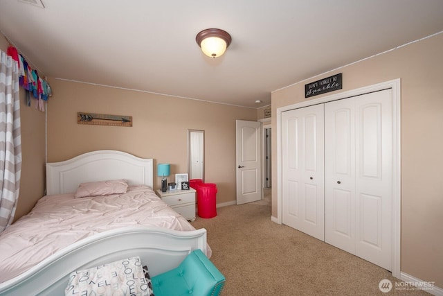 bedroom with a closet, baseboards, and carpet