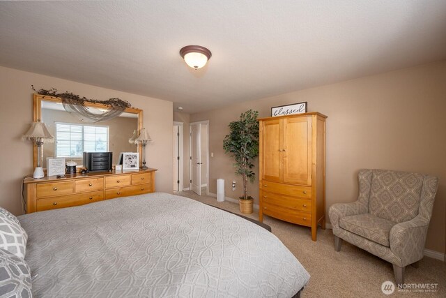 bedroom featuring light carpet and baseboards