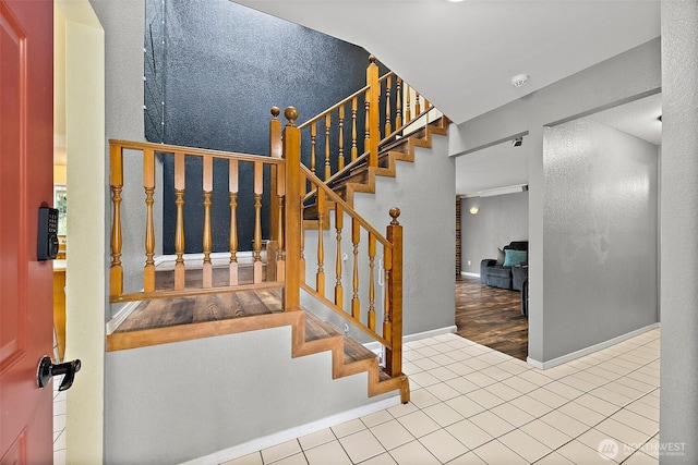 staircase with tile patterned floors and baseboards