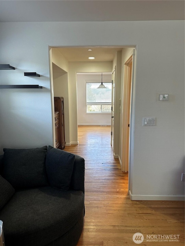 hallway with light wood-style floors and baseboards