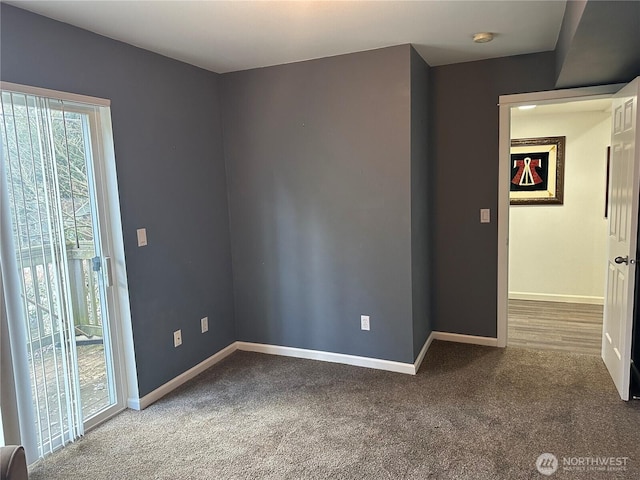 carpeted spare room featuring baseboards