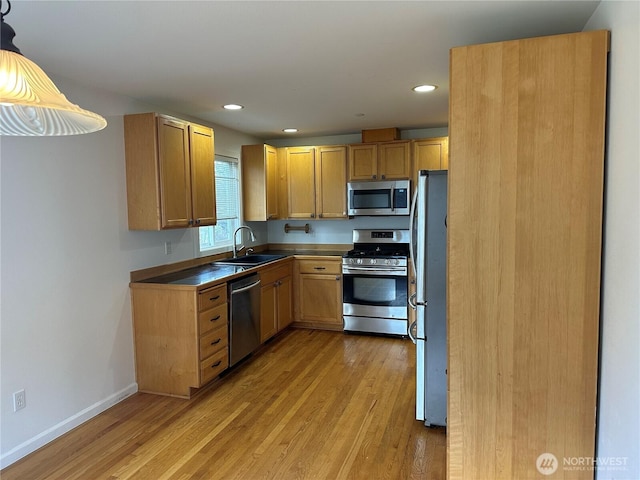 kitchen featuring recessed lighting, a sink, baseboards, appliances with stainless steel finishes, and light wood finished floors