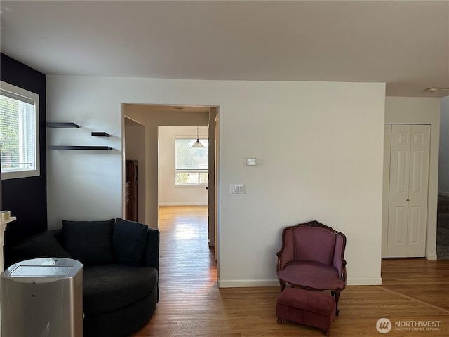 sitting room featuring a healthy amount of sunlight, baseboards, and wood finished floors