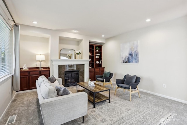 living room with a fireplace, baseboards, light colored carpet, and recessed lighting