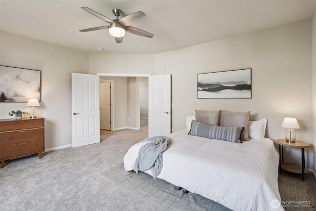 bedroom featuring light colored carpet, a ceiling fan, and baseboards