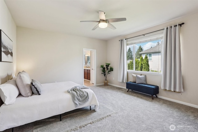carpeted bedroom with baseboards, ceiling fan, and ensuite bathroom