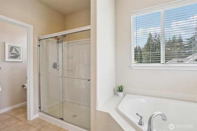 full bath featuring plenty of natural light, a stall shower, a garden tub, and tile patterned floors