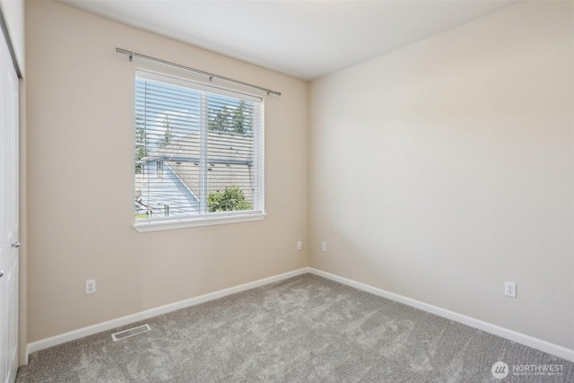 empty room featuring carpet and baseboards