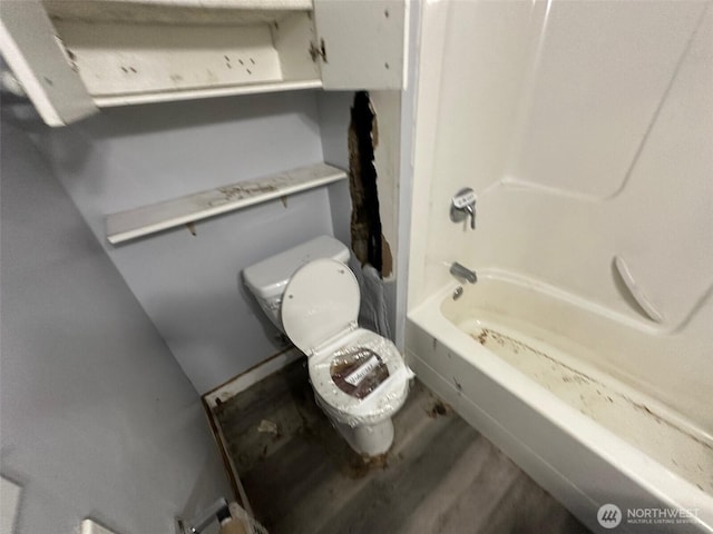 bathroom featuring toilet, bathtub / shower combination, and wood finished floors