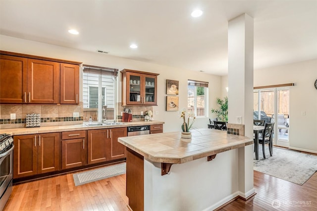 kitchen featuring brown cabinetry, visible vents, and a sink